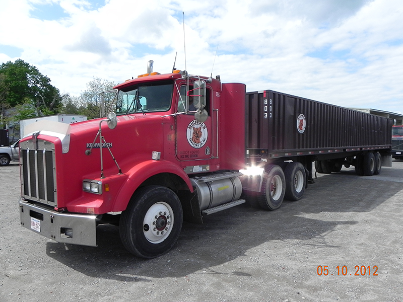 A Nichols Kenworth pulling an ocean shipping container on a chassis