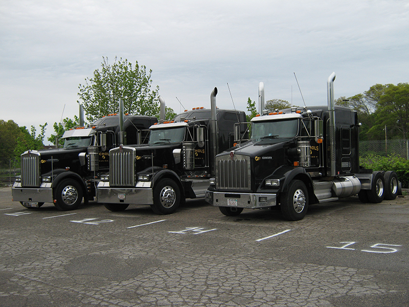 A lineup of black Nichols Kenworth tractors parked in the company yard